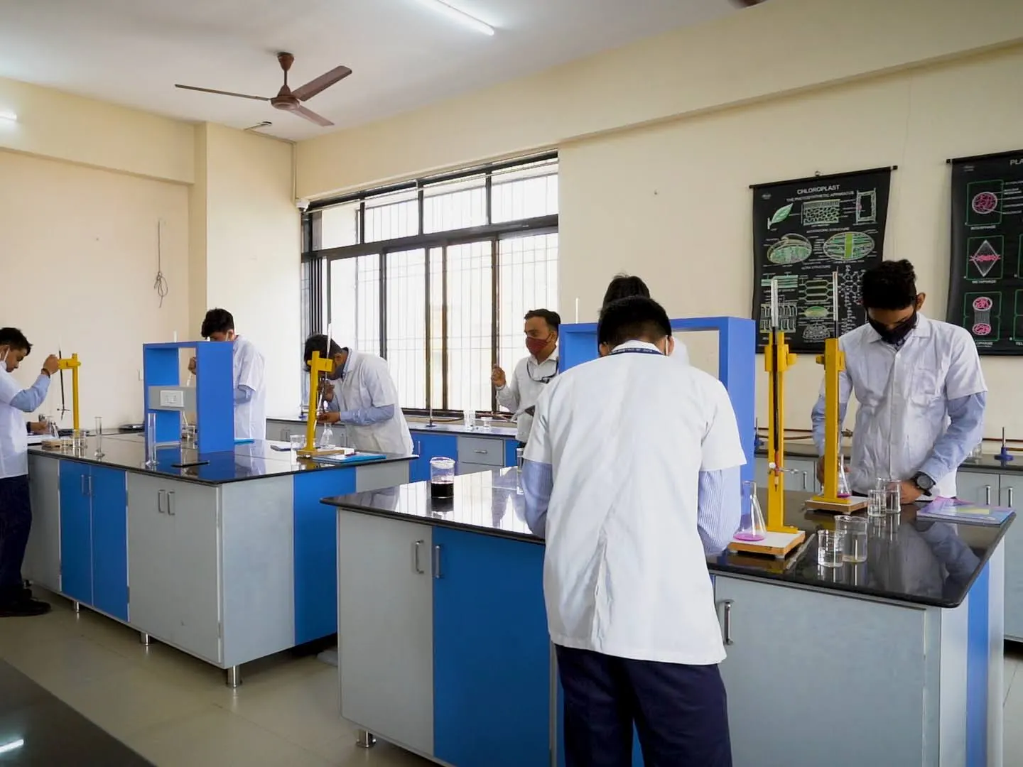 Students in lab coats doing an experiment in the science lab