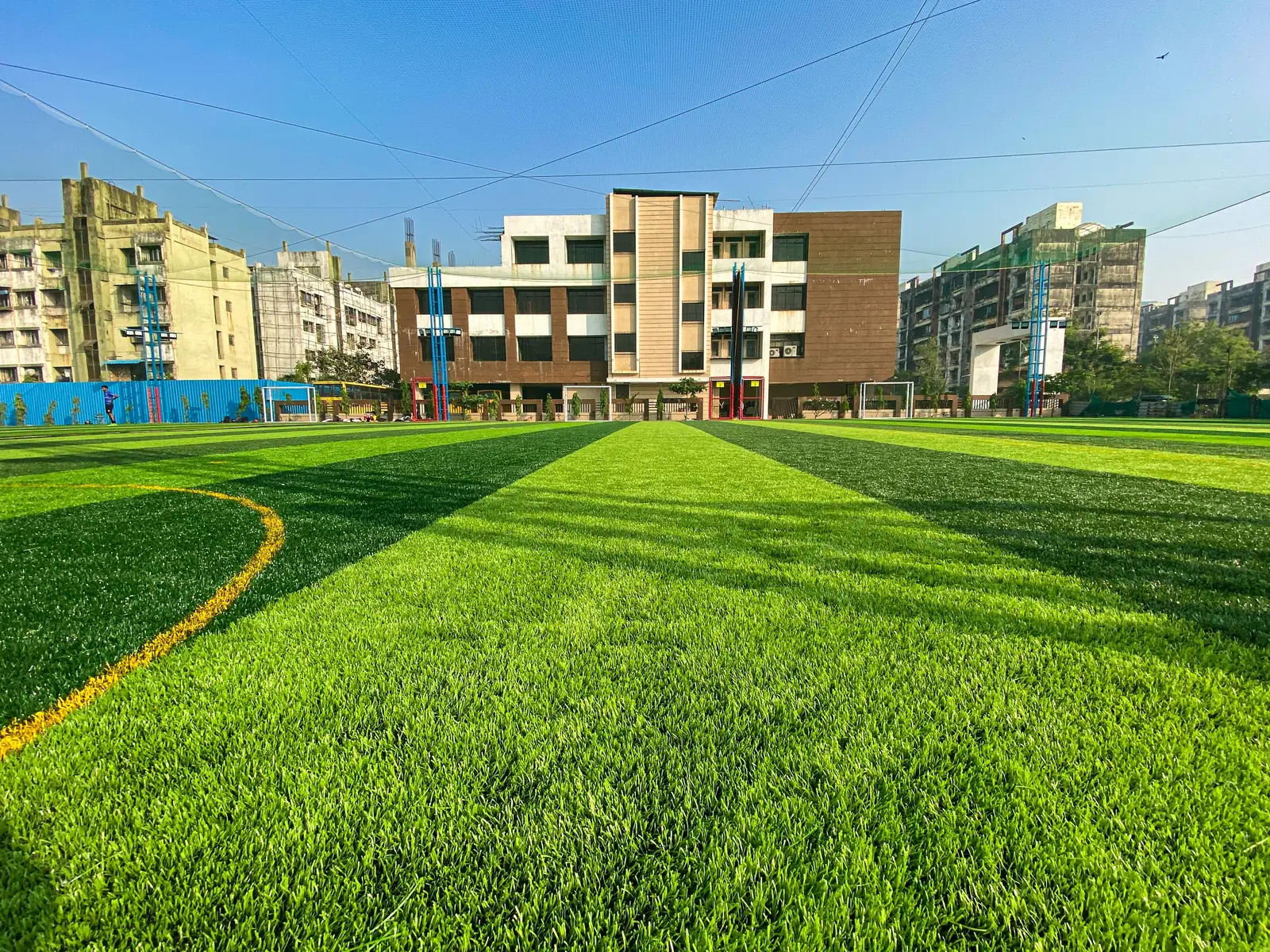 The football turf in the morning sun, with the school behind it